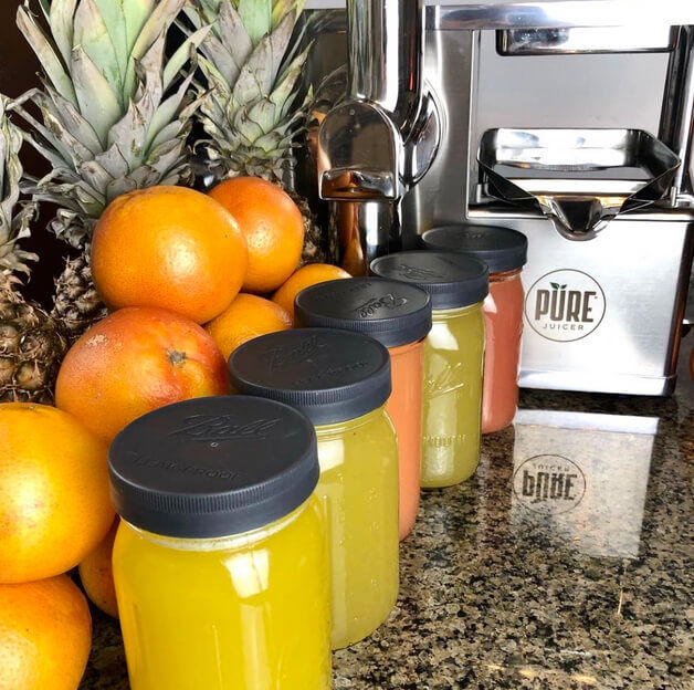 Orange juice, PURE juicer, and fruit