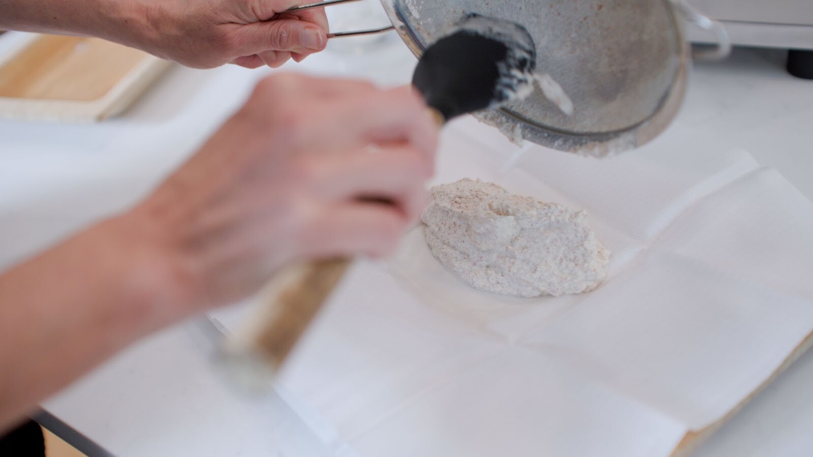 Freshly blended almond meal is scooped onto a PURE press cloth before folding.
