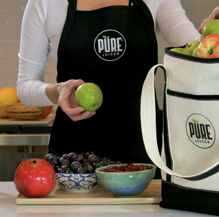 apple and pomegranate being put into a PURE juicer bag 