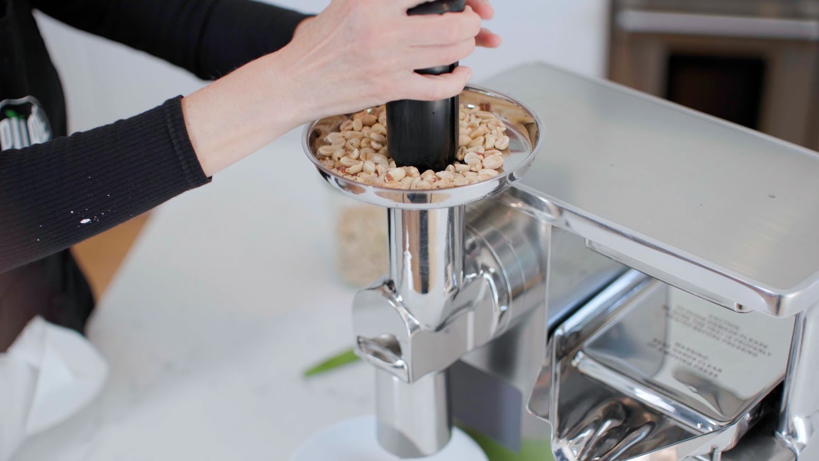 pouring roasted nuts into juicer
