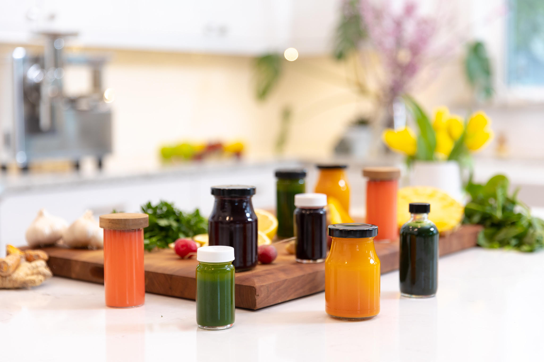 A lot of small glass containers with different types of juice.